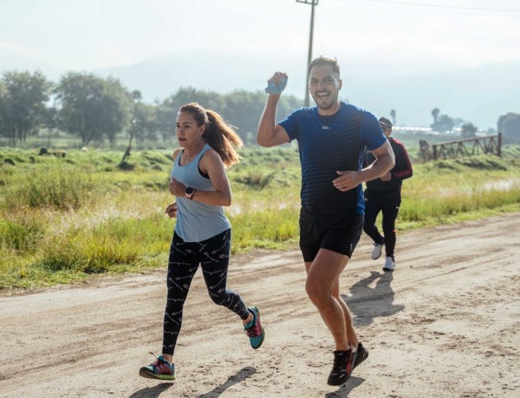 A group of runners enjoys a vibrant morning jog on a rural dirt road.