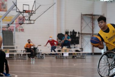 Dynamic wheelchair basketball game showcasing skill and determination indoors.